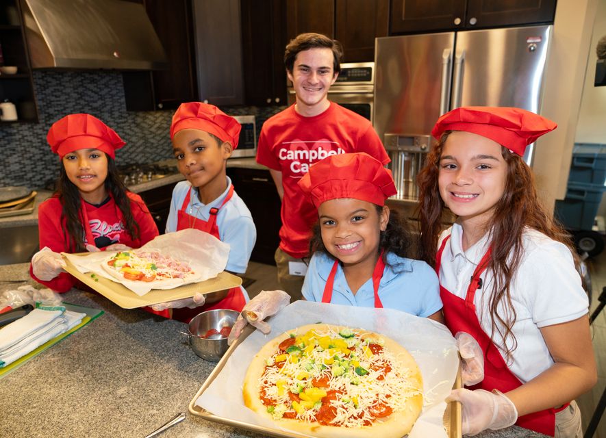 Cooking Matters kids holding up pizza creations